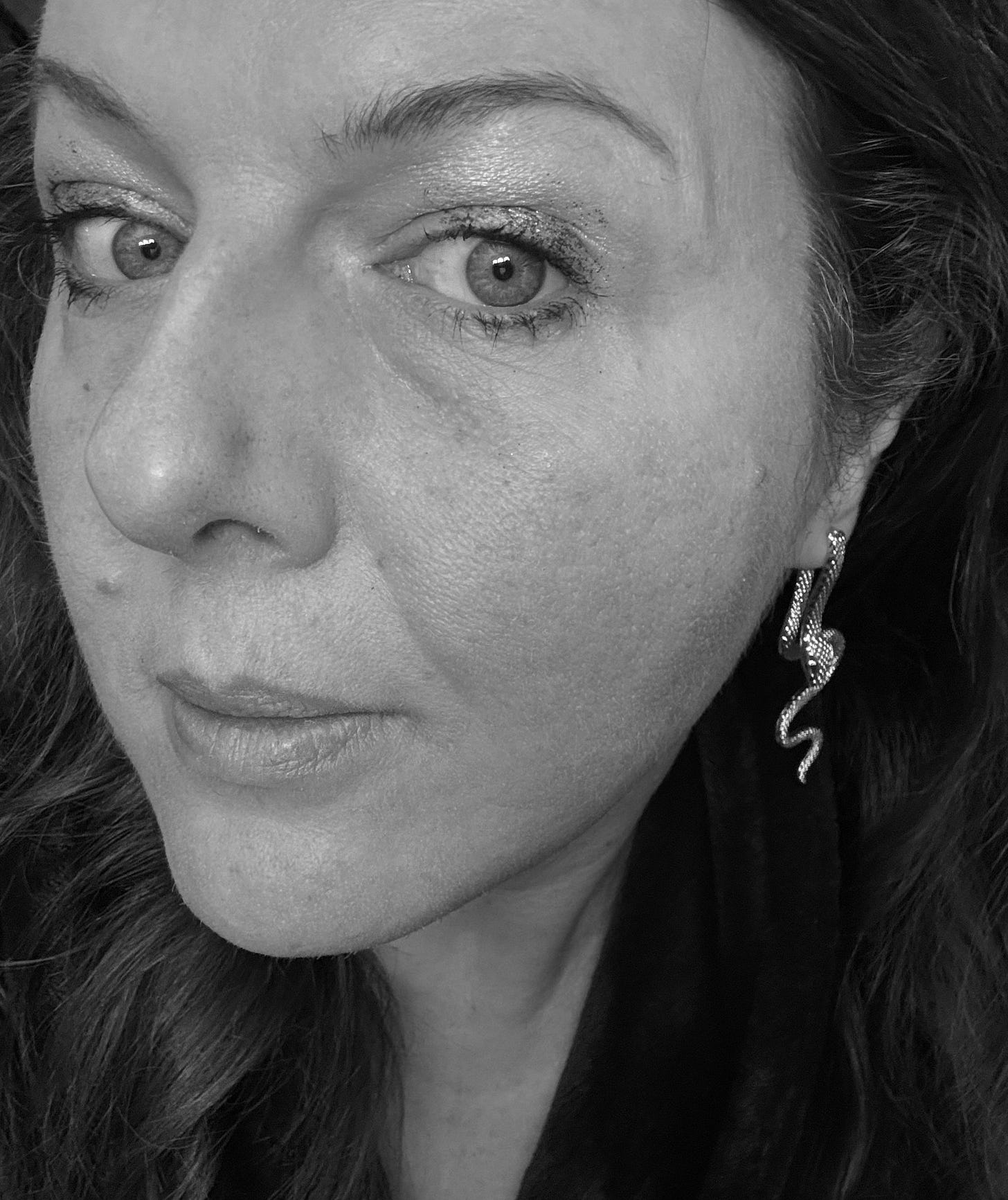 Black and white image of woman wearing snake earring