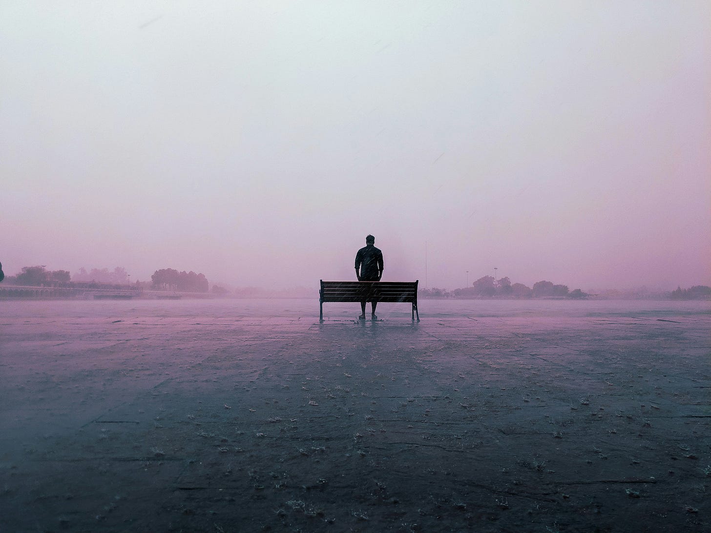 man standing by bench on foggy day