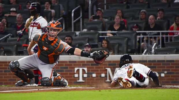 The Atlanta Braves' Dansby Swanson scores as San Francisco Giants...