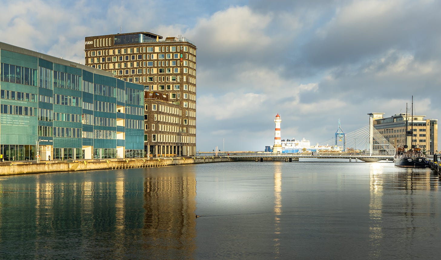 A body of water with buildings and a lighthouse

AI-generated content may be incorrect.