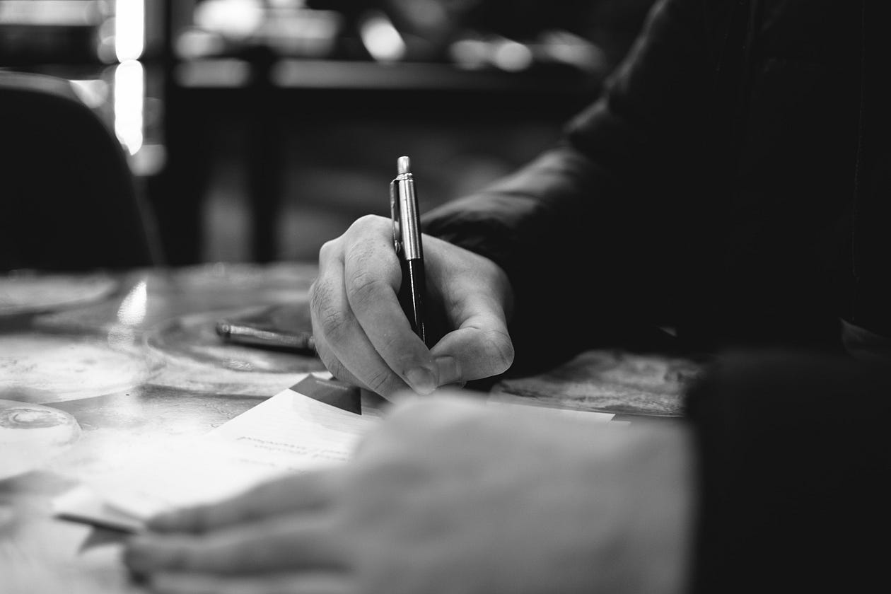 a person writing on a paper a person writing on a paper