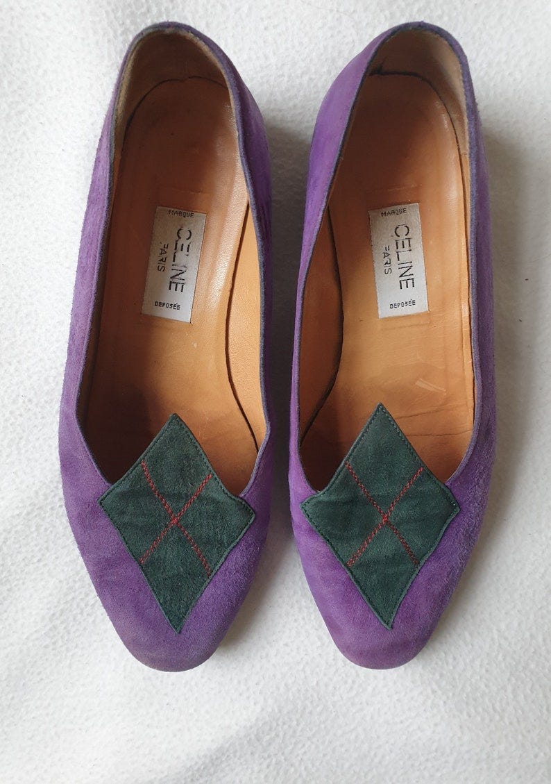 May include: A pair of purple suede shoes with green suede diamond-shaped accents. The shoes have a label on the inside that reads 'CELINE PARIS MARQUE DEPOSEE'. May include: A pair of purple suede shoes with green suede diamond-shaped accents. The shoes have a label on the inside that reads 'CELINE PARIS MARQUE DEPOSEE'.