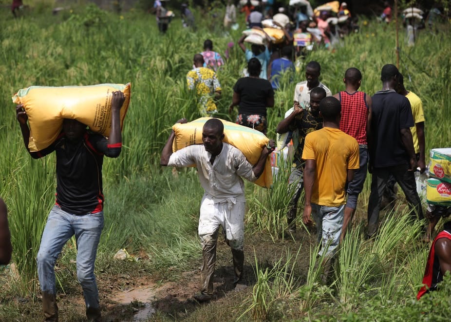 People carrying bags of food on thier heads and shoulder People carrying bags of food on thier heads and shoulder