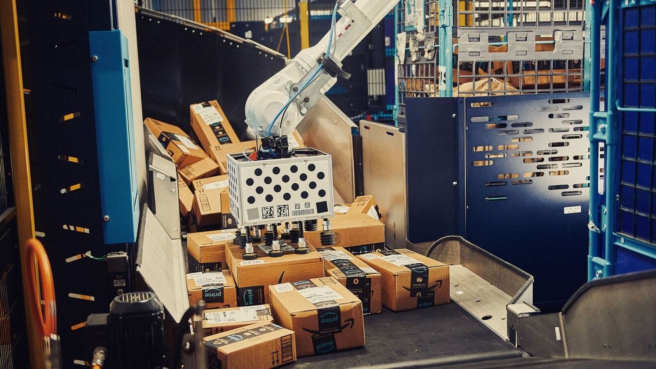 An Amazon robotic arm, Cardinal, moves packages from a conveyor belt to bins to be brought to the delivery trucks.