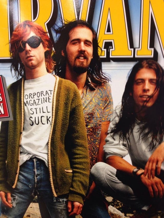r/Nirvana - Kurt Cobain wearing his "Corporate magazines still suck" t-shirt on the cover of Rolling Stone.