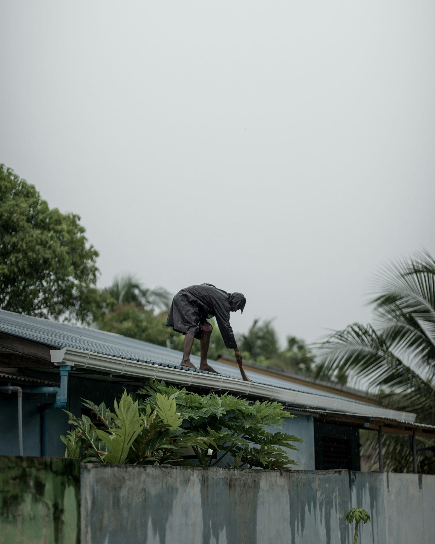 Belizean man checking his roof before a storm
