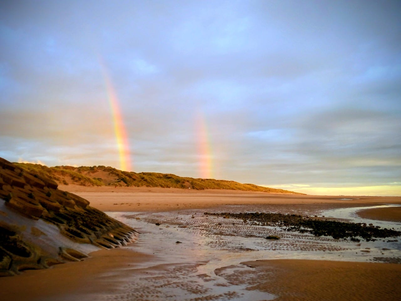 Double rainbow over sand dunes