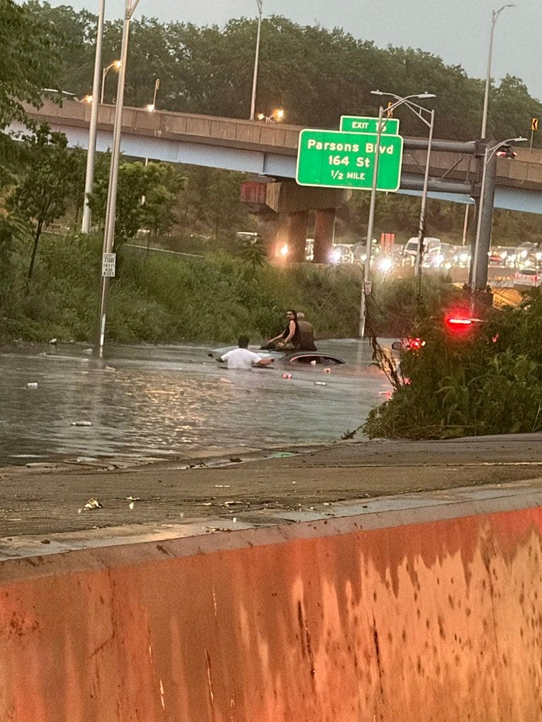 Civilians aiding trapped motorists in flooding on the Jackie Robinson Parkway in Queens.