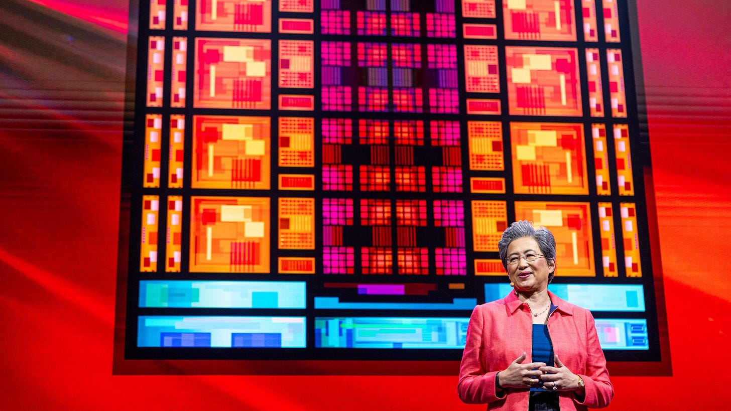 photo of a woman with short gray hair wearing glasses standing on stage against a screen showing a vibrant silicon chip photo of a woman with short gray hair wearing glasses standing on stage against a screen showing a vibrant silicon chip