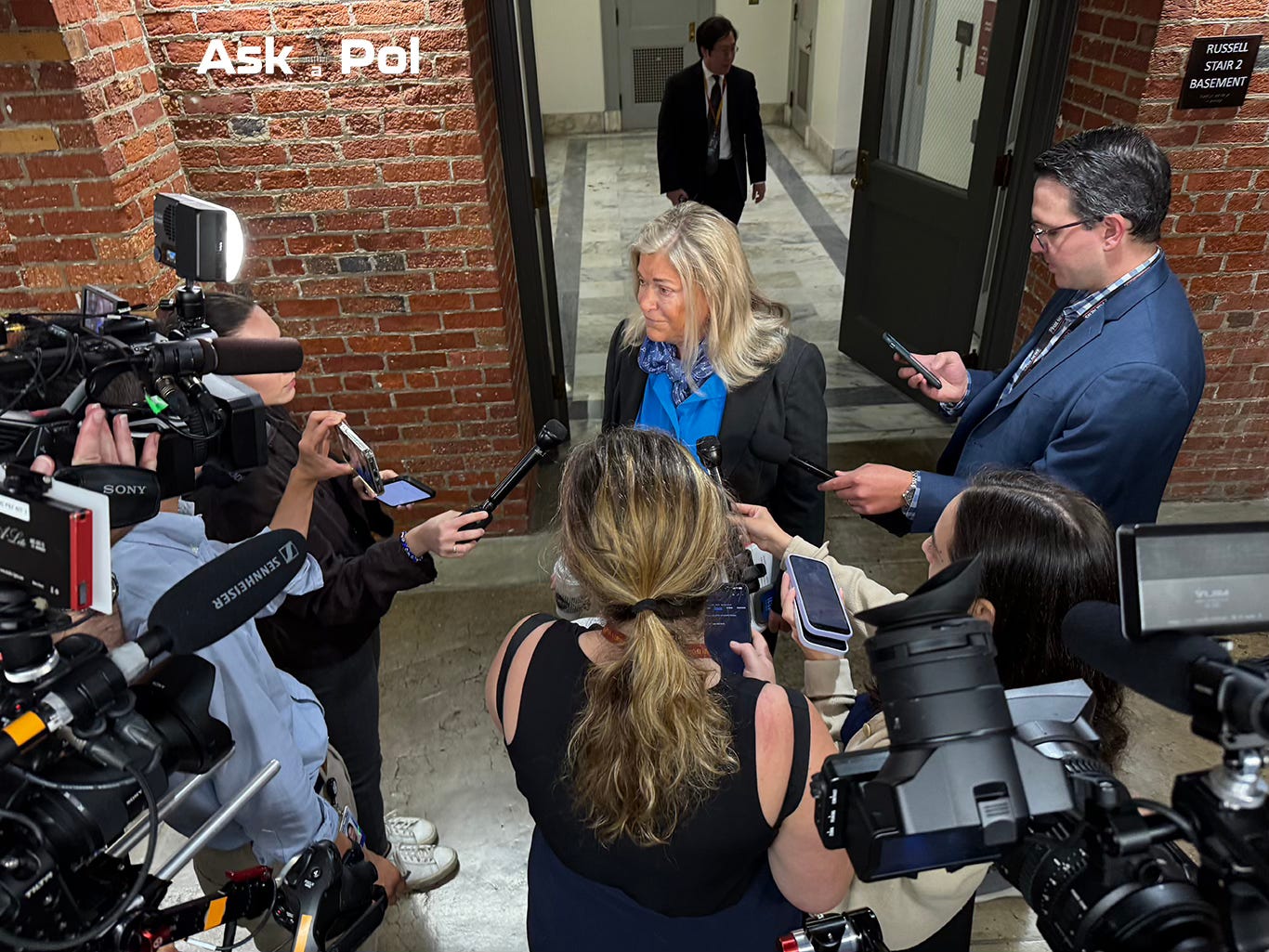 A female Senator is encircled by reporters asking her questions. Photo: Matt Laslo © www.askapol.com