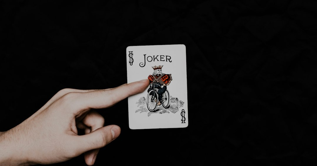a person holding a playing card in their hand a person holding a playing card in their hand