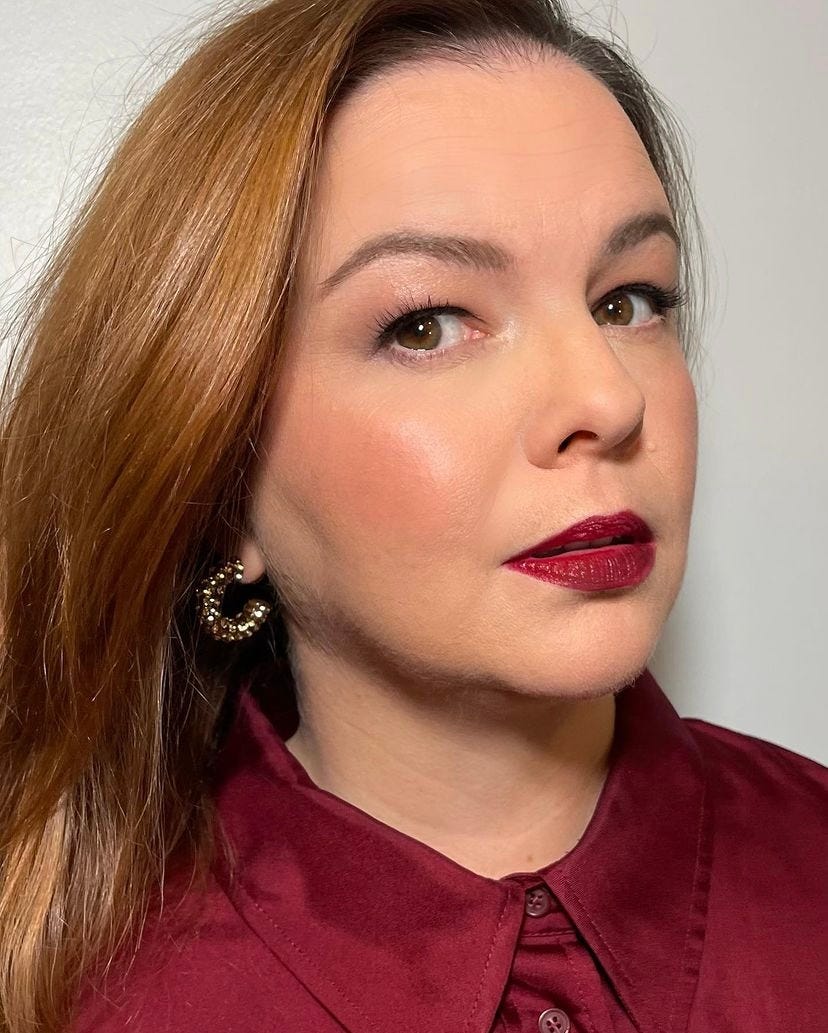 A close-up of Amber. She’s in slight profile but looking at the camera. A close-up of Amber. She’s in slight profile but looking at the camera.