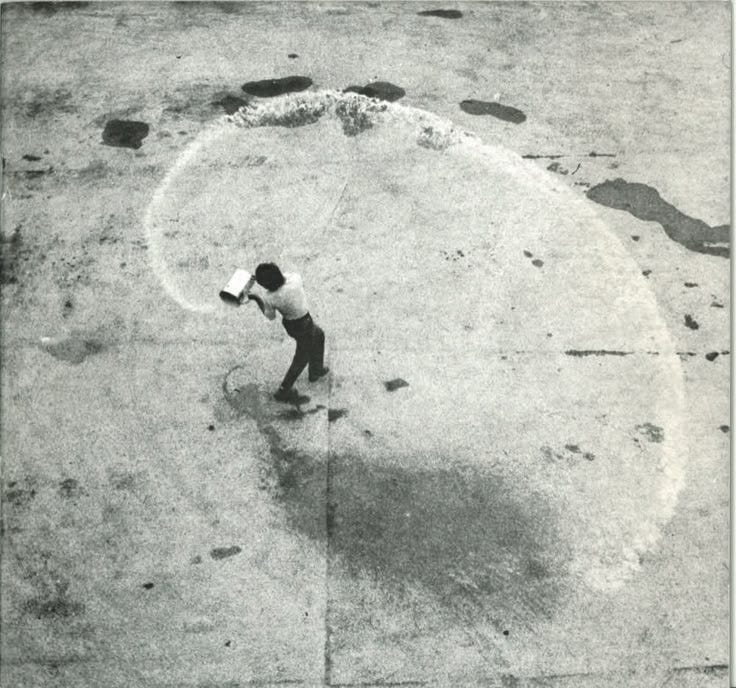 This may contain: a man standing on top of a cement ground holding a frisbee in his hand