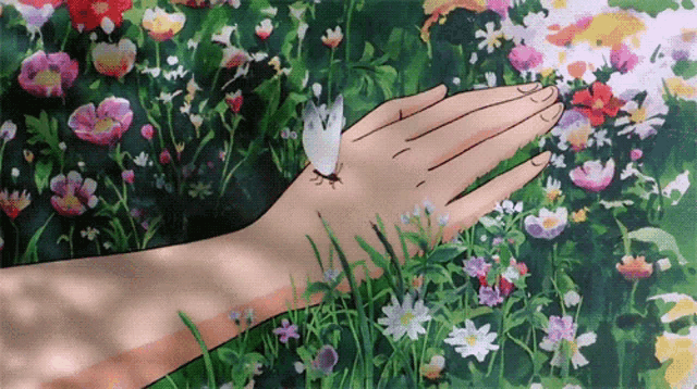 a butterfly is sitting on a person 's hand in a field of flowers a butterfly is sitting on a person 's hand in a field of flowers