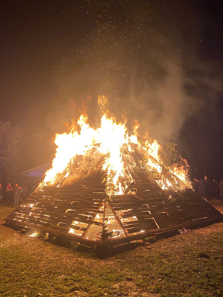Series of images of large timber pyramid structure in open space as fire takes hold and it burns to the ground