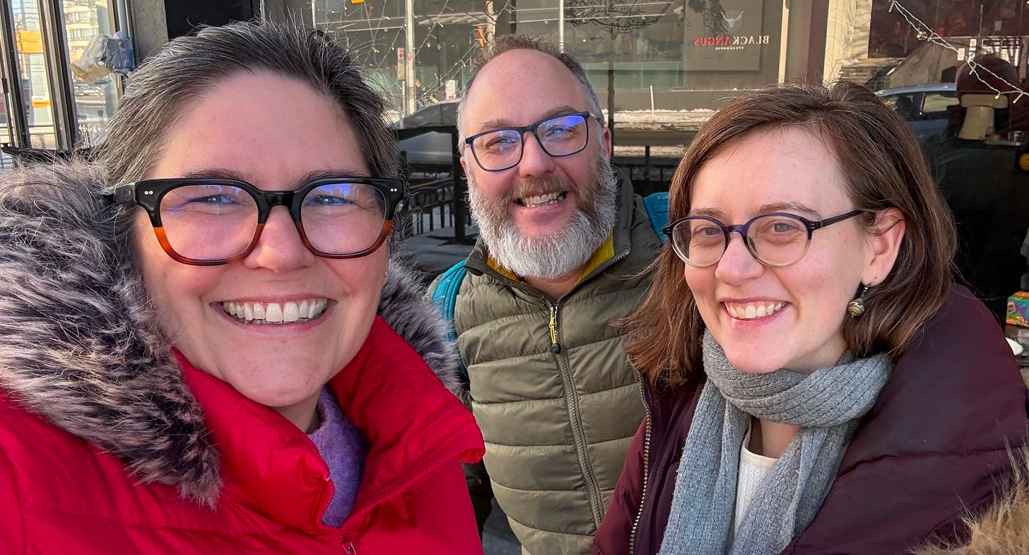 Three ministers in winter coats on a sidewalk