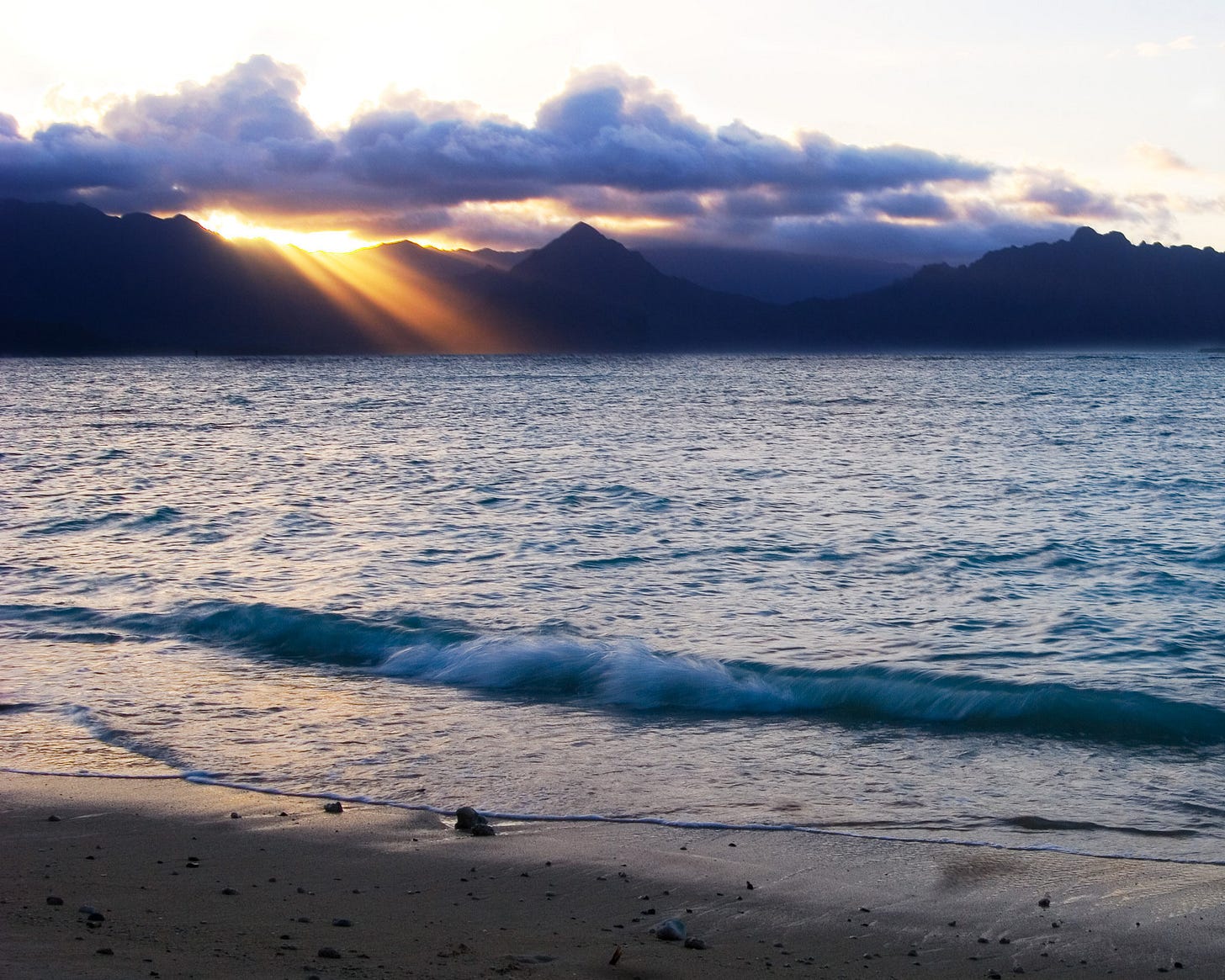 Sunset over the mountains at a beach in Hawaii