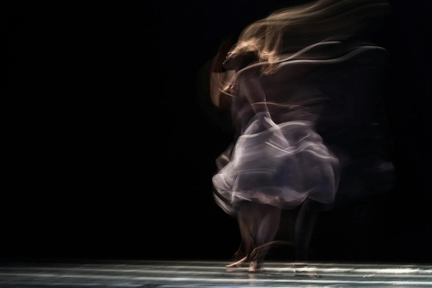 Dancer in a blur, fabric billowing around her like captured moonlight