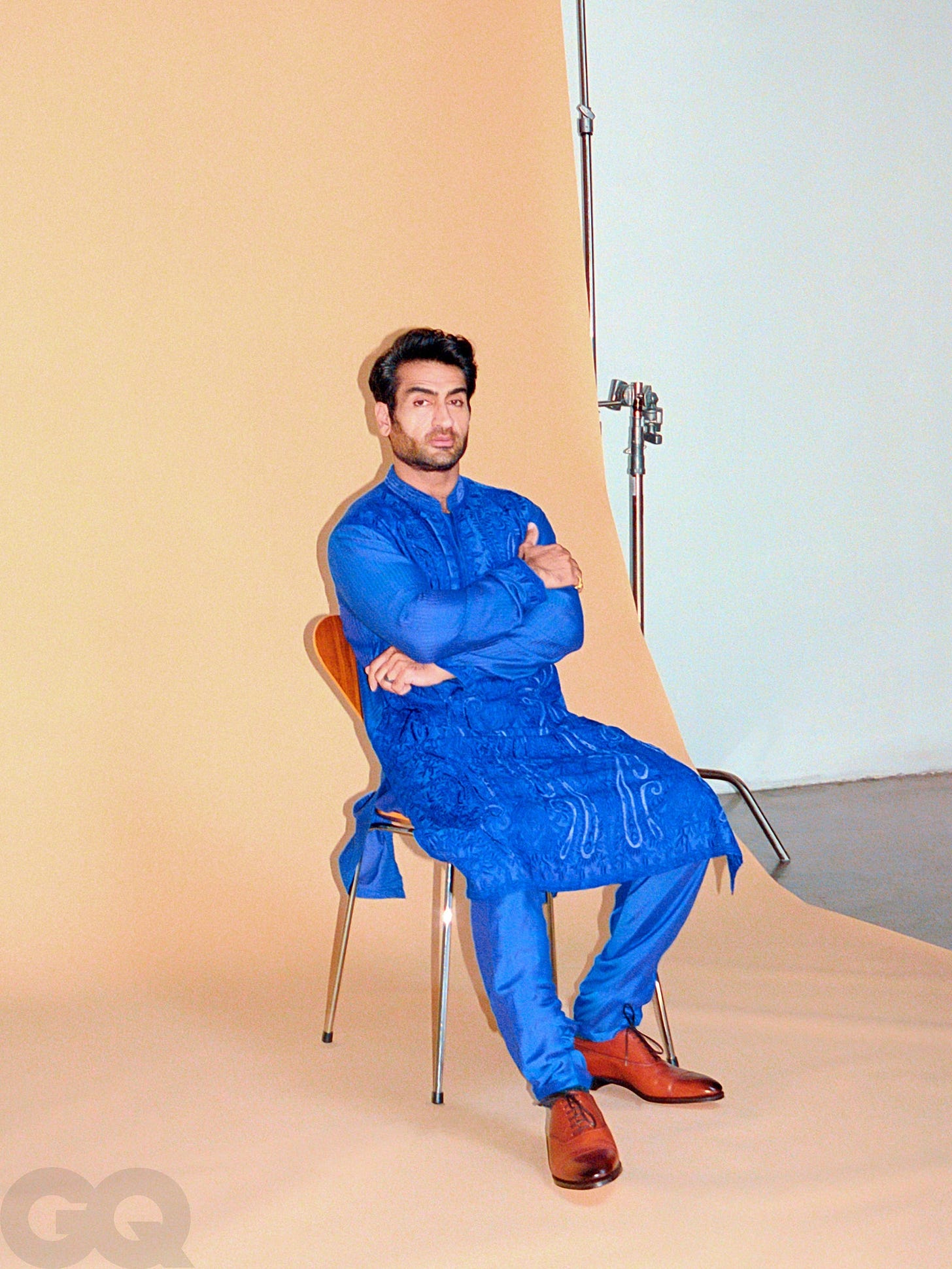 Image may contain Clothing Apparel Furniture Chair Kumail Nanjiani Human Person Dress Footwear Shoe and Pants