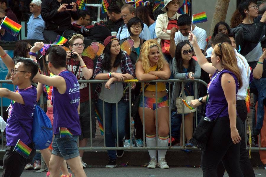 San Francisco'daki bir onur yürüyüşünden bir foto. Kortejden birkaç kişi görünüyor yakında, ellerinde bayraklar. Arkada, demir çitlerin arkasında birkaç genç, yüzlerinde dünya tatlısı bir gülümseme, geçenleri seyrediyorlar. San Francisco'daki bir onur yürüyüşünden bir foto. Kortejden birkaç kişi görünüyor yakında, ellerinde bayraklar. Arkada, demir çitlerin arkasında birkaç genç, yüzlerinde dünya tatlısı bir gülümseme, geçenleri seyrediyorlar.
