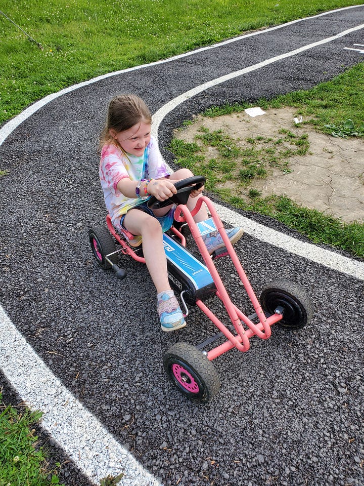 Each photo features a very determined child on a small pedal-driven go-kart type thing on a little paved track.