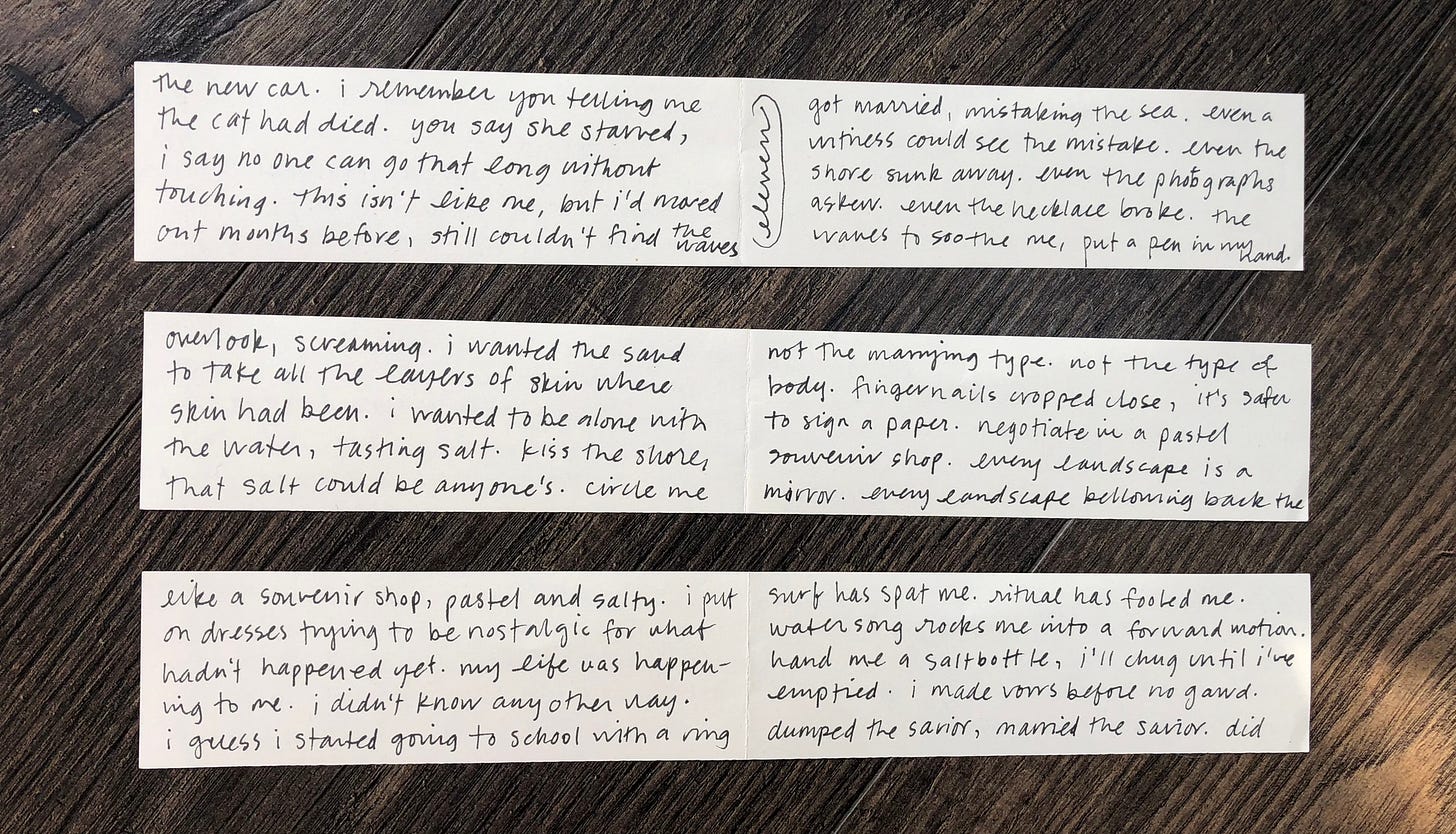 three paper scraps with black ink handwriting laid out neatly on a wood floor with visible fold marks at center