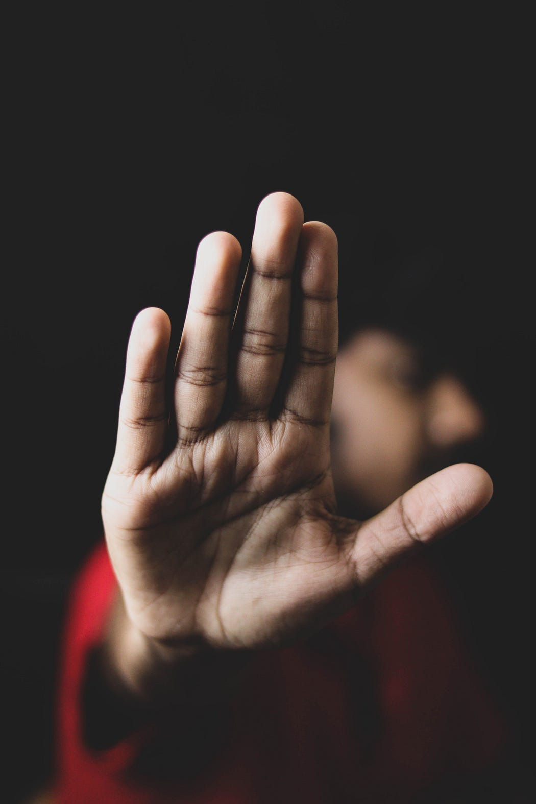 A photograph of a person showing their hand towards the viewer.