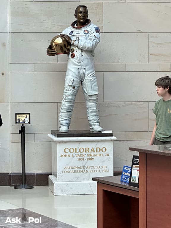 A kid walks past a marble statue of an astronaut carrying his helmet. Photo Matt Laslo for © www.askapoluaps.com