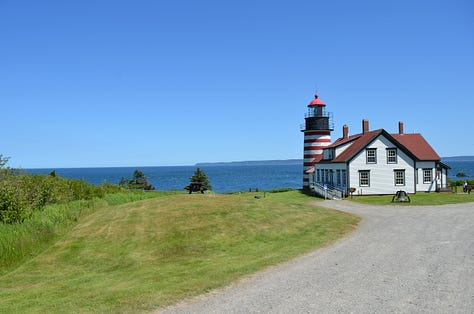 Lighthouse in Maine with rocky beaches and children playing.