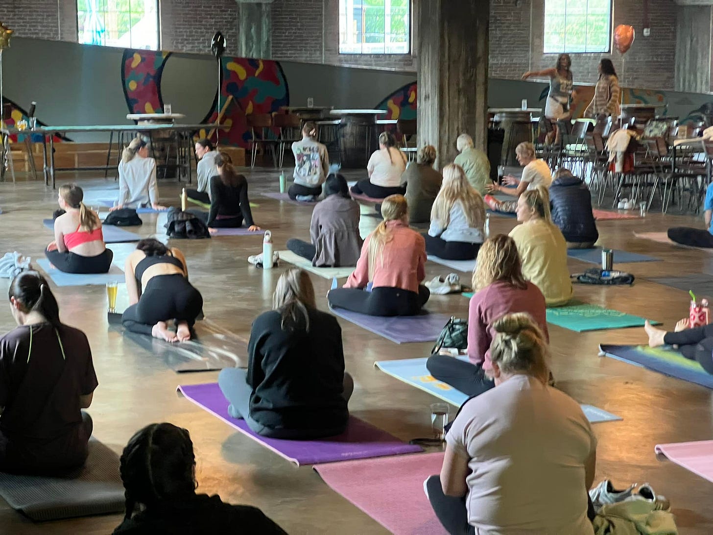 May be an image of 18 people, people practicing yoga and crowd