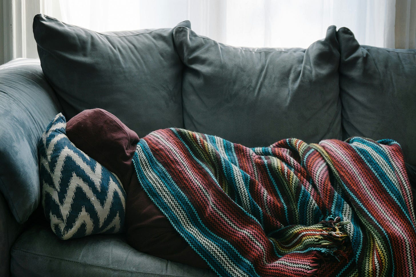 Person sleeping on the couch with a blanket. Person sleeping on the couch with a blanket.