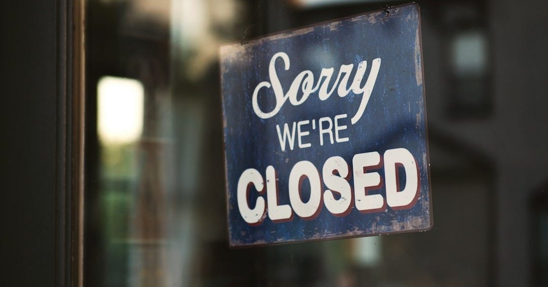 Sorry we're closed signage hanged on glass door Sorry we're closed signage hanged on glass door