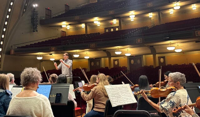 A photo of a man conducting an orchestra