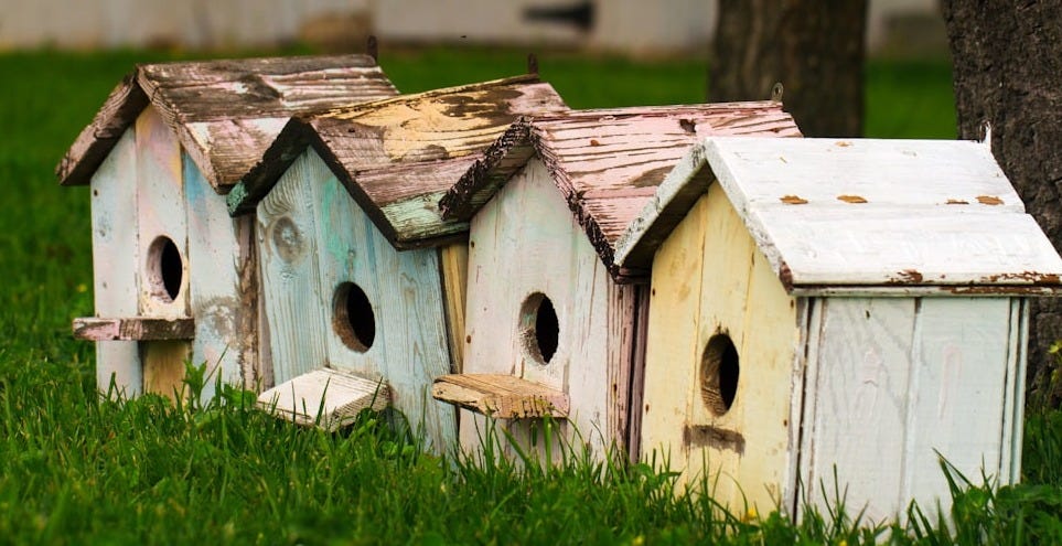 four birdhouses on grass