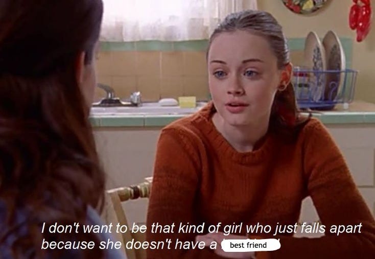 This may contain: a woman sitting at a table in front of a window talking to another woman who is wearing an orange sweater