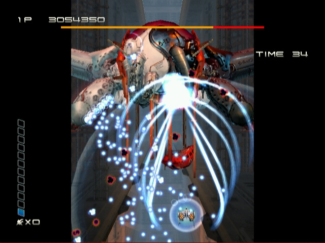 Level 2 boss of Ikaruga on the GameCube. The ship is enveloped by white energy bullets emanating from the boss, but but is holding its own well and reflecting back a retaliatory white energy ray back into the core of the attacking ship. This level is perhaps on of the most beautiful examples of mathematical balance and fluid game dynamics in the modern shoot 'em up era.