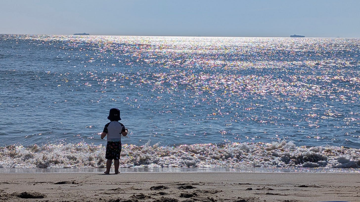 a little kid in front of the ocean