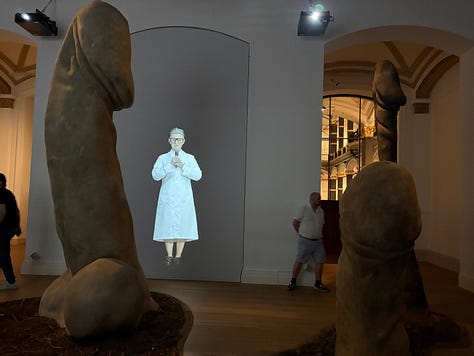 Left: a woman in a lab coat in a video projection narrates the work; Center: the remnants of a burned star from one of Abromovic's earliest installations with black and white photographs of the fire on the wall; Right: the table and star set-up of a live installation when Abromovic carved the star symbol into her abdomen as a performance.