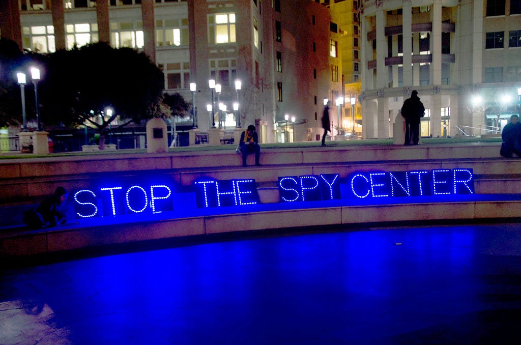 Sign protesting the Domain Awareness Center at Frank H. Ogawa Plaza. Oakland, California, February 4, 2014. (Image source: Daniel Arauz / Creative Commons) Sign protesting the Domain Awareness Center at Frank H. Ogawa Plaza. Oakland, California, February 4, 2014. (Image source: Daniel Arauz / Creative Commons)