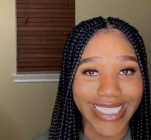 This may contain: a woman with braids smiling for the camera