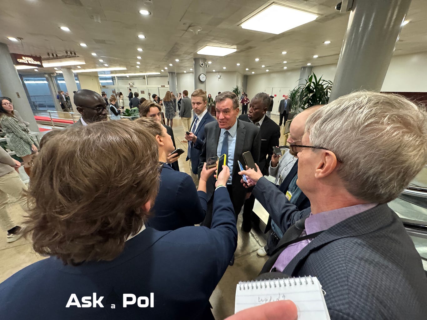 A male politician in a suit is surrounded by reporters holding their phones out to record him in basement of US Capitol A male politician in a suit is surrounded by reporters holding their phones out to record him in basement of US Capitol