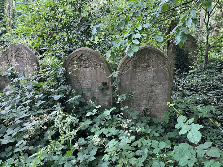 Six headstones with inscriptions of handshakes in a woodland cemetery