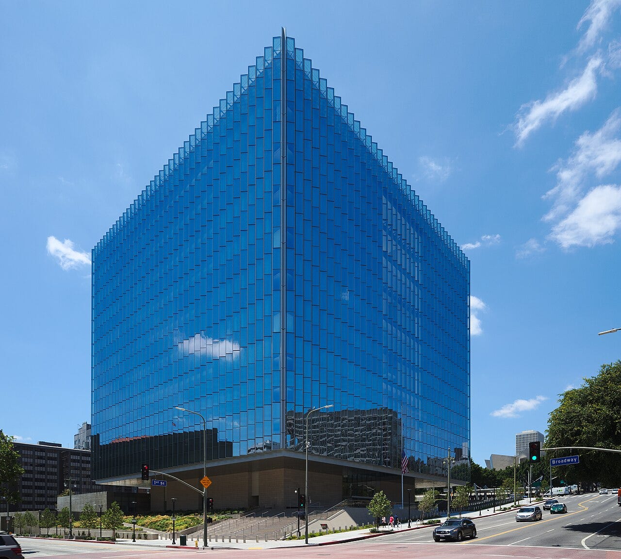 Glass-fronted federal courthouse at a street intersection in downtown Los Angeles under a blue sky. Glass-fronted federal courthouse at a street intersection in downtown Los Angeles under a blue sky.