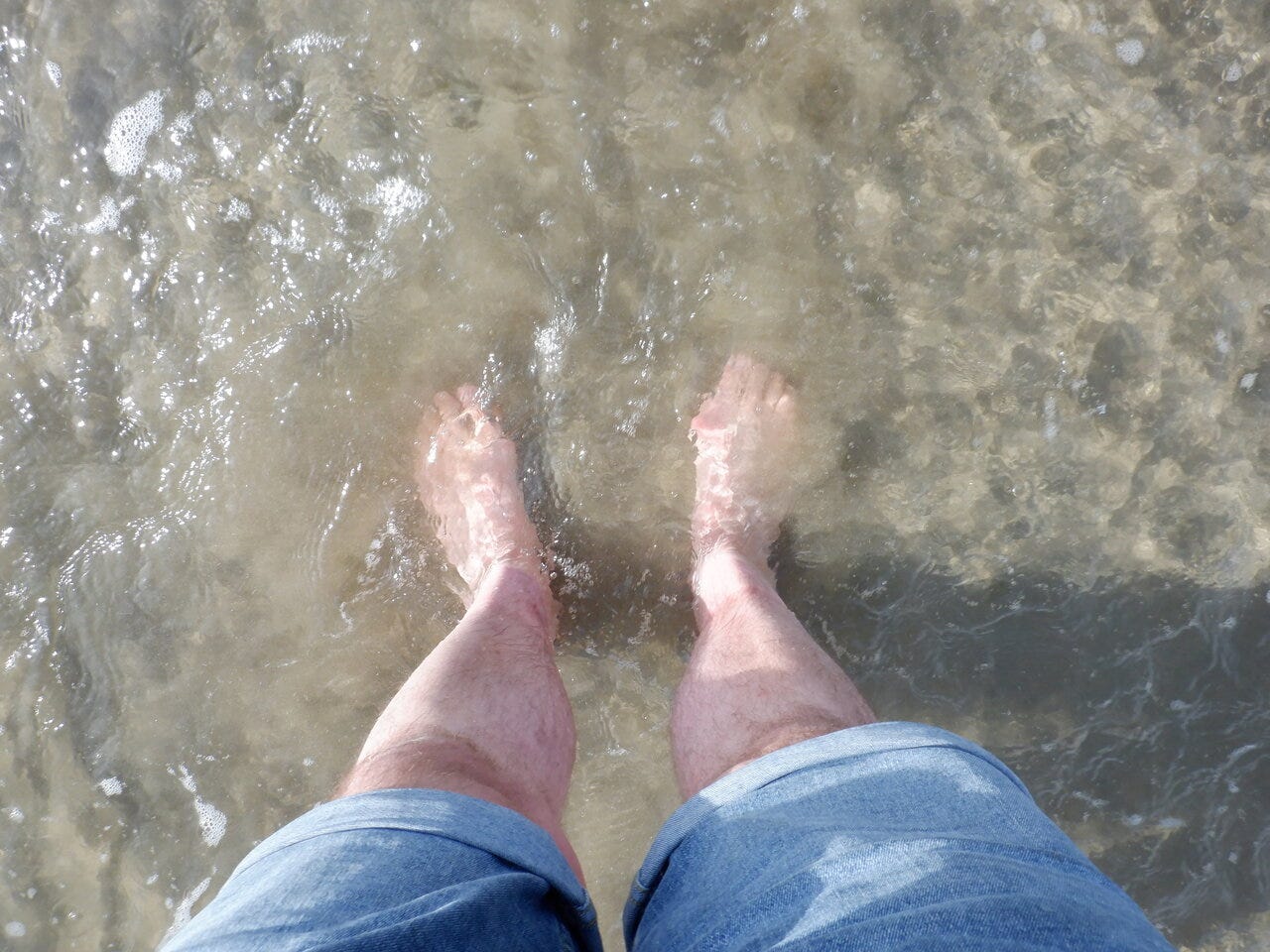 Bare feet in shallow sea water