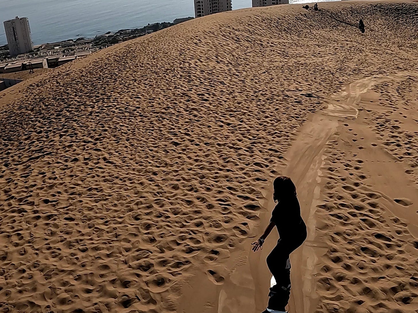 La autora haciendo sandboard en la mayor duna urbana del mundo en Iquique. Foto propia. La autora haciendo sandboard en la mayor duna urbana del mundo en Iquique. Foto propia.