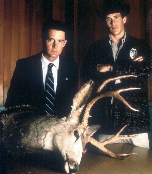 A couple of men posing with a deer
Description automatically generated