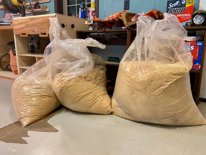 Woodworking pieces, bags of sawdust, and sawdust spread amongst the farm animals.