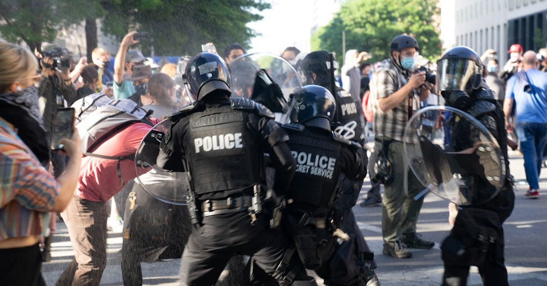 people in black police uniform riding on elephant during daytime people in black police uniform riding on elephant during daytime