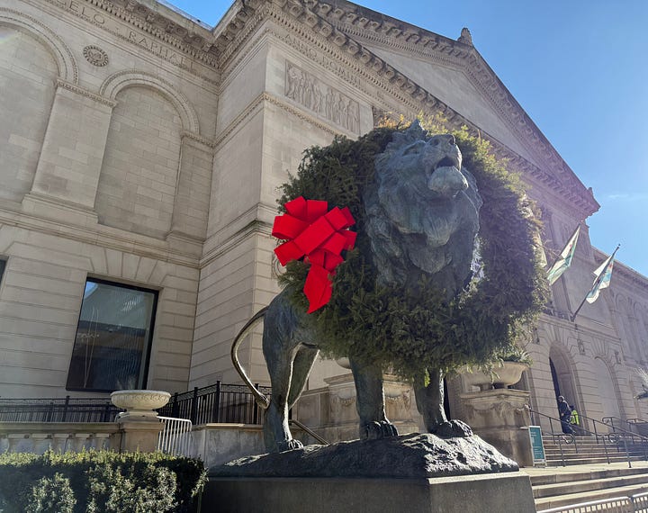 Exterior of the Art Institute of Chicago with lion sculpture wearing a holiday wreath; framed portrait of the poet Rilke with a full beard