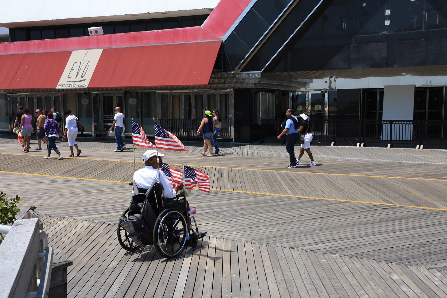 A man in a wheelchair sells US flags in front of the shuttered Trump Plaza casino